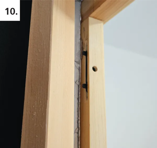 Hinge the jamb leg into place behind casing, using beveled edge against pocket door